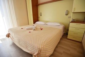 Un dormitorio con una cama con rosas. en Silvi Marina Sea Resort, en Silvi Marina