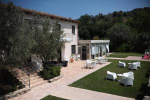 a garden with white chairs and tables and a building at Kasale B&B Country House in Torretta