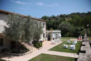 a garden with white furniture and a house at Kasale B&B Country House in Torretta