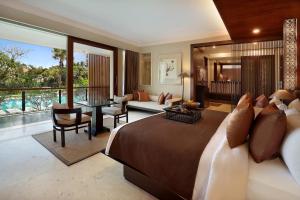 a bedroom with a large bed and a living room at Royal Kamuela Villas & Suites at Monkey Forest Ubud - Adult Only in Ubud
