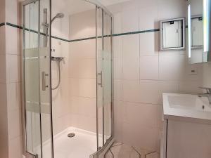 een badkamer met een douche en een wastafel bij Boucanier 002, appartement avec jardin in Verbier