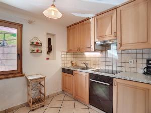 een keuken met houten kasten en een fornuis met oven bij Boucanier 002, appartement avec jardin in Verbier