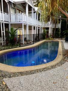 a swimming pool in front of a house at The Queenslander Fullmoon in Port Douglas