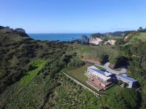 an aerial view of a house on a hill with the ocean at Hahei Ocean Dream in Hahei
