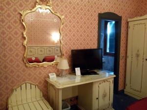 Cette chambre comprend un bureau avec un ordinateur et un miroir. dans l'établissement Antico Panada, à Venise