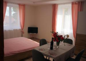 Un dormitorio con una mesa con flores y una cama en Apartmánový dom Mária en Banská Štiavnica