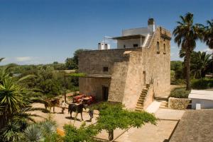 a large stone building with a horse standing in front of it at Agriturismo Masseria Gianferrante in Ugento