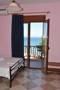 a bedroom with a bed and a view of the ocean at Karatzas in Karfas
