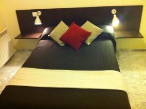 a hotel room with two beds and a lamp at Hostal Neptuno in Cáceres