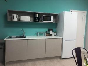 a kitchen with a white refrigerator and a sink at Albergue Augas Quentes in Ourense