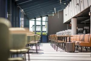 - une rangée de tables et de chaises dans une pièce dotée de plafonds bleus dans l'établissement Studio's De Vlijt Texel, à De Cocksdorp