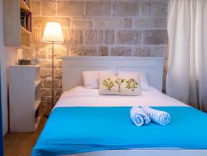 a bedroom with a white bed with two towels on it at ECO Aparthotel The Dreamers's Club in Lumbarda
