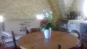 a vase of flowers sitting on a wooden table at Le Pigeonnier du Château in Saint-Victor-de-Malcap +25 photos