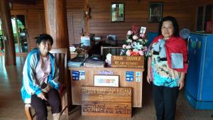 two women standing next to a desk in a room at Huanmaisakngam Resort in Ban Buak Khang