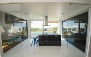a kitchen with glass walls and a kitchen island at Palmares Beach, Golf & Dream in Lagos