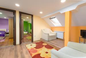een woonkamer met een bank, een stoel en een televisie bij Serdika Round Tower Apartments in Sofia
