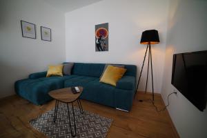 Una sala de estar con un sofá azul y una mesa. en Villa Korona Apartments, en Zadar
