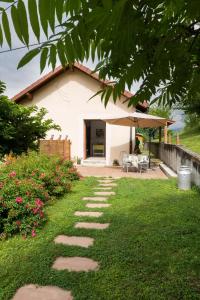 a garden with a stone path in front of a house at Le Paradis des Animaux in Coublevie