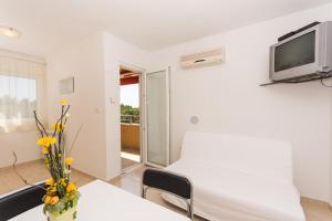 Zimmer mit einem Bett und einem TV an der Wand in der Unterkunft Apartments Vukman in Trogir