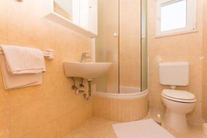 ein Badezimmer mit Toilette, Waschbecken und Dusche in der Unterkunft Apartments Vukman in Trogir + 13 Fotos