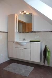 ein Bad mit einem Waschbecken und einem Spiegel in der Unterkunft Ferienwohnung Faber mit großem Südbalkon in Essing