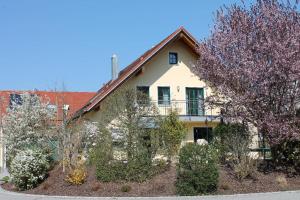 ein Haus mit blühenden Bäumen davor in der Unterkunft Ferienwohnung Faber mit großem Südbalkon in Essing