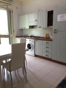 ガリポリにあるBaia Verde Biloのキッチン(食器洗い機、テーブル、椅子付)