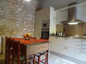 eine Küche mit einem Holztisch und eine Küche mit weißen Schränken in der Unterkunft Esglesia 10 in Alcúdia