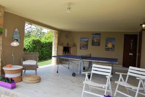 un patio con mesa de ping pong y sillas en Sunny Holiday Home, en Creixell