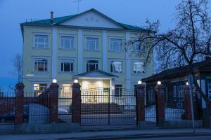 a white house with a gate in front of it at Гостевая усадьба"Никольская" in Tyumen