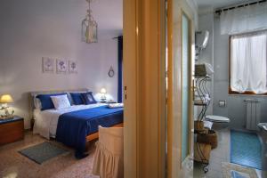 una camera con letto blu e un bagno di Green House Adriana a Sorrento