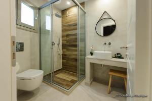 uma casa de banho com um chuveiro, um WC e um lavatório. em Alfa Hotel em Parga