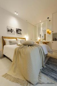 een slaapkamer met een groot bed met een deken erop bij Alfa Hotel in Parga
