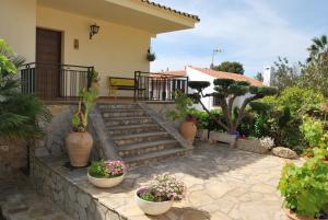 a house with stairs and potted plants in front of it at Sunny Holiday Home in Creixell