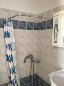 a bathroom with a shower curtain and a sink at Eugenia travasarou sea view appartments in Diakofti