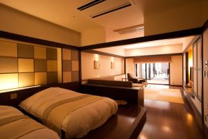 a bedroom with two beds and a living room at Lake Shikotsu Tsuruga Resort Spa Mizu no Uta in Chitose