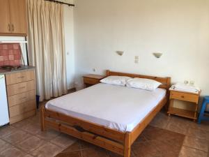 a small bedroom with a bed and a kitchen at Eugenia travasarou sea view appartments in Diakofti