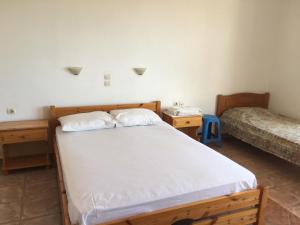 a bedroom with a bed and two night stands at Eugenia travasarou sea view appartments in Diakofti