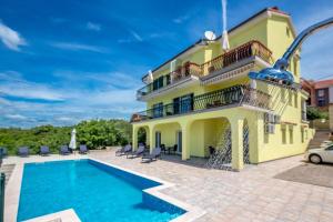 a villa with a swimming pool and a house at Luxury apartments Kostrena with pool in Kostrena