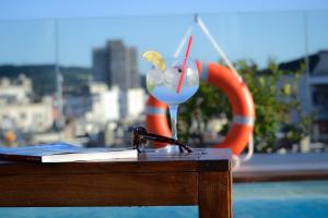 a desk with a book and a drink on a table at Hotel America Barcelona in Barcelona