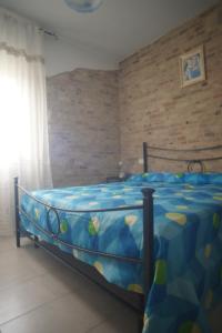 Schlafzimmer mit einem Bett mit blauer Decke in der Unterkunft Casale Giordano in Scerni