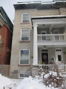 una casa con un pilar blanco en la nieve en Australis Guest House, en Ottawa