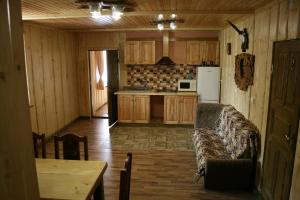 a kitchen with a couch and a table in a room at Котедж Ялівець in Kolochava