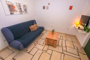 a living room with a blue couch and a table at Apartments Erika in Rogoznica