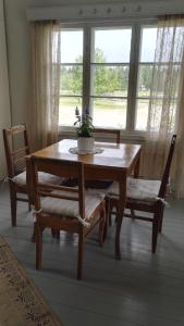 a dining room table and chairs with a table and a window at Suomela Camping in Kärsämäki