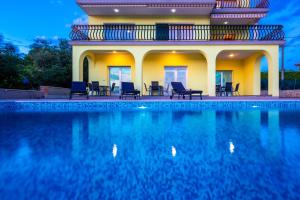 a house with a swimming pool in front of it at Luxury apartments Kostrena with pool in Kostrena