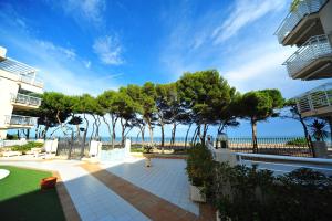 a patio with a view of the beach and trees at Cala Gonzalez Superior Orange Costa in Alcossebre