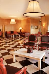 a lobby with chairs and tables on a checkered floor at Hotel Real Oeiras in Oeiras
