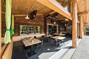 a restaurant with wooden walls and tables and chairs at Hotel Ustria Parlatsch in Trin