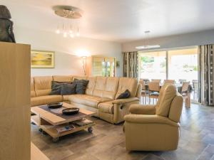 a living room with a couch and chairs and a table at Modern holiday home with swimming pool in Saint-Nexans